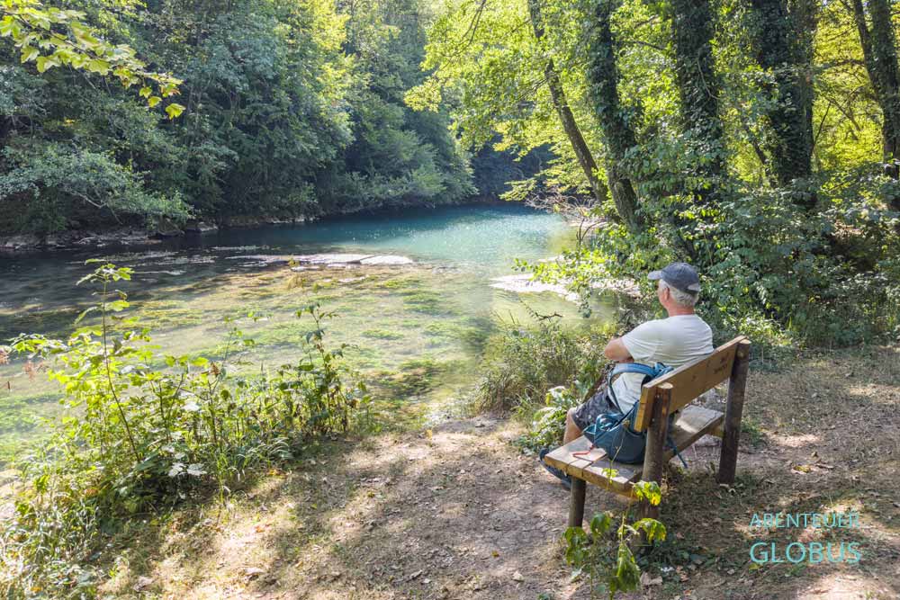 Wanderer auf einer Bank am Ufer der Slunjcica in Slunj, Kroatien