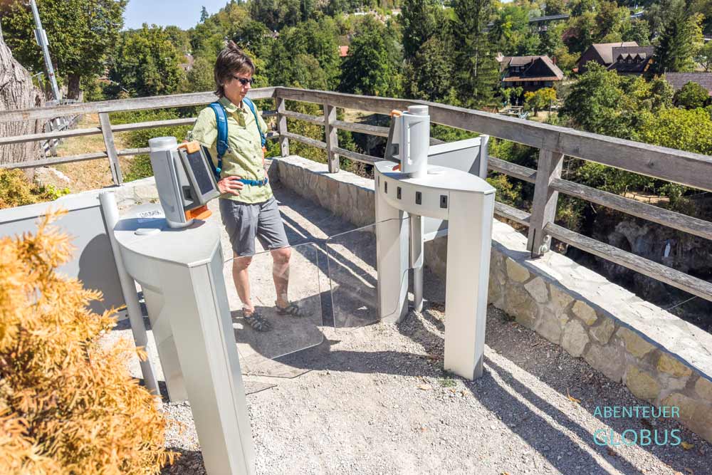 Besucherin vor der Zugangsschranke an der Brücke am Rundweg in Rastoke, Ortsteil von Slunj, in Kroatien